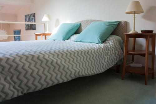 a bedroom with a bed with blue pillows on it at Maison de Pêcheur in Toulon