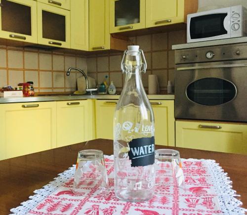 - une bouteille de vin assise sur une table avec deux verres dans l'établissement Lakes&Hills Apartments, à Erba