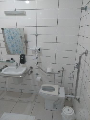 a bathroom with a toilet and a sink at Rota do Sol Praia Hotel in Guaratuba