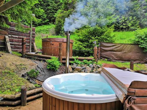 a jacuzzi tub in a garden with a fence at Penzión Pod Guglom in Mlynky 