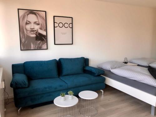 a living room with a blue couch and a bed at Deluxe Apartments Messe Flughafen in Leinfelden-Echterdingen