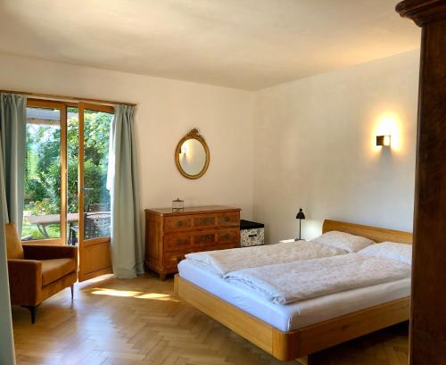ein Schlafzimmer mit einem Bett, einem Stuhl und einem Fenster in der Unterkunft Casa al Sole in Morcote