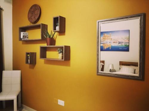 a mirror on a yellow wall in a room at Seabreeze Apartment in St Paul's Bay