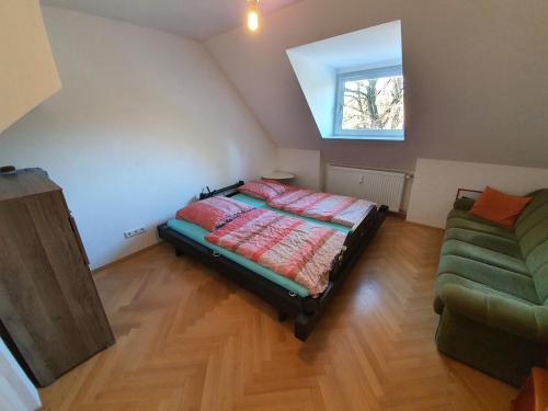 a bedroom with a bed and a couch and a window at Idyllische Penthouse-Wohnung in super Lage in Munich