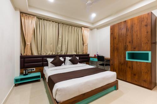 a bedroom with a large bed and a window at The Grand Shaurya in Indore