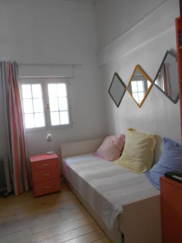 a bedroom with a bed with two pillows and a mirror at Maison de Pêcheur in Toulon