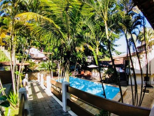um resort com piscina e palmeiras em ILHABEACH Suítes e Chalés em Ilhabela