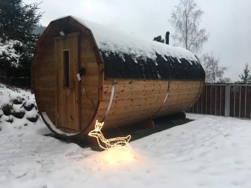 a small wooden hut in the snow with a fire at Roubenka Ella in Desná