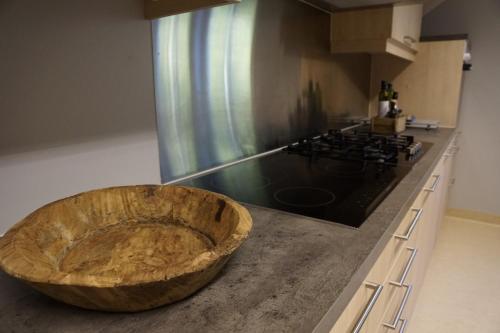 a kitchen with a wooden bowl on top of a counter at Nyken Resort - The apartment in Nyksund