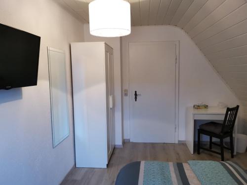 a room with a white door and a chair and a desk at COLE`s WALLS in Walsrode