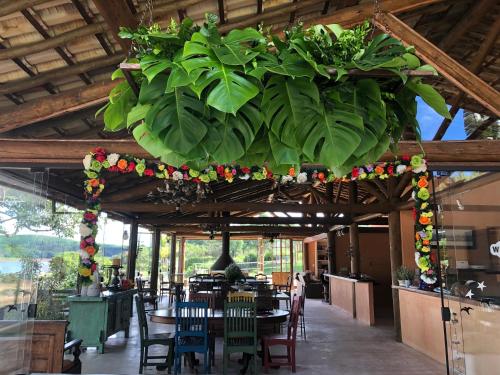 a restaurant with a bunch of plants hanging from the ceiling at Pousada Ecológica Espelho D'Água in Carrancas