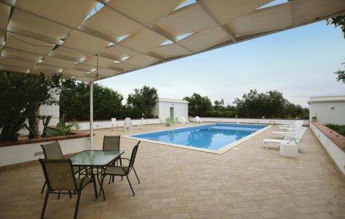 eine Terrasse mit einem Tisch, Stühlen und einem Pool in der Unterkunft Villa Calò in Castelvetrano Selinunte