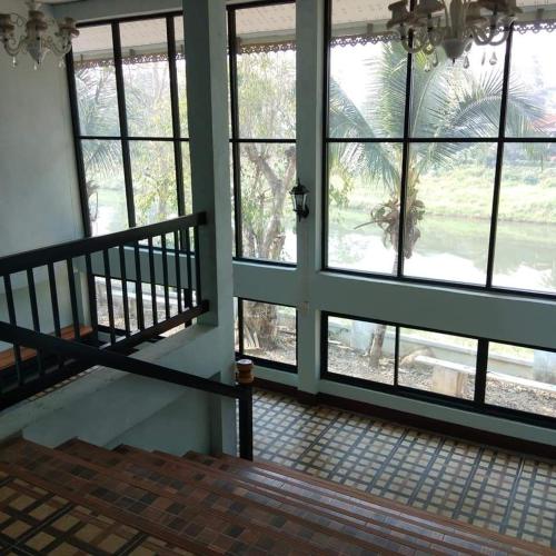 an empty room with large windows and a staircase at Wangtong Resort 2 in Ban Huai Salok