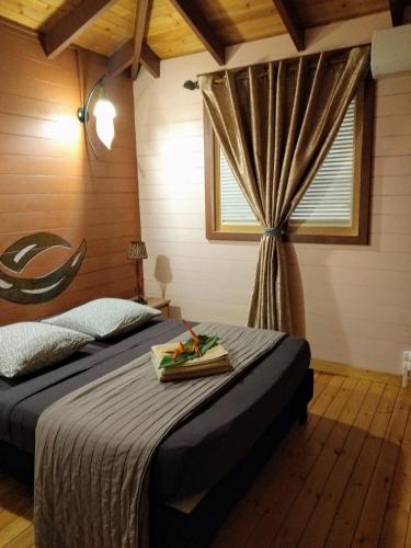 a bedroom with a bed and a window at Villa & Bungalow Fleur de Coco in Sainte-Anne