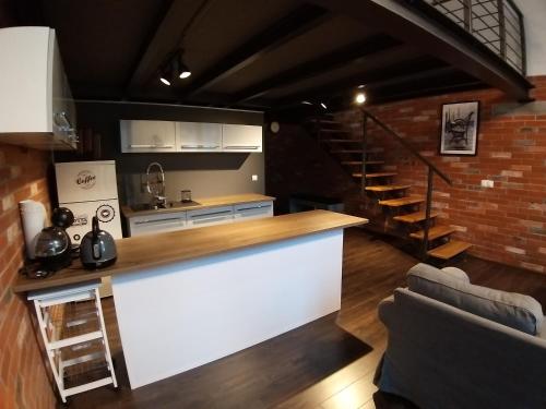 a kitchen with a white counter and a brick wall at LOFT 314 in Żyrardów