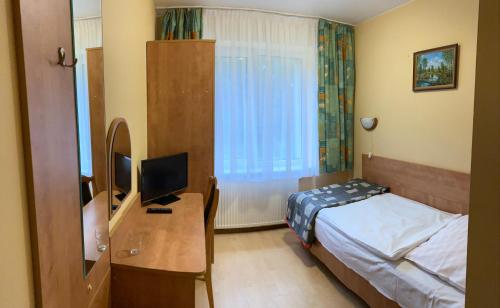 sypialnia z łóżkiem i biurkiem z telewizorem w obiekcie Zajazd Saga w mieście Gryfino