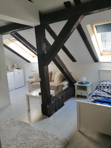 a bedroom with exposed beams and a bed and a couch at Miaap Apartments in Sarajevo