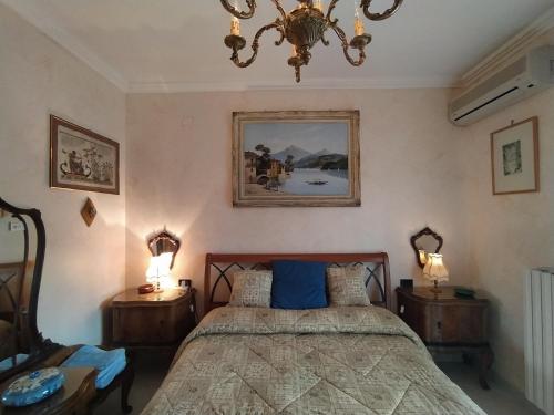 巴勒瑟的住宿－The Architect，一间卧室配有一张带2个床头柜和吊灯的床。