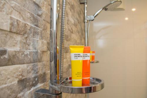 a shelf in a bathroom with orange and yellow cleaning products at Tussen Gracht en SintJan in Den Bosch