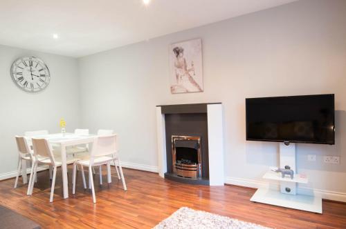 a dining room with a table and a tv on a wall at Atlas House - Ideal for Contractors or Derby County Fans in Derby