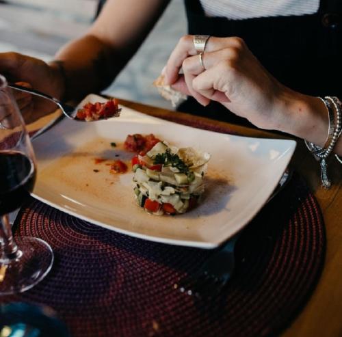 une personne mangeant un morceau de nourriture sur une assiette dans l'établissement Le lodge de La Boissière, à Andillac