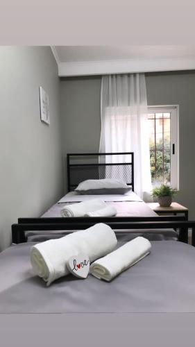2 Betten in einem Schlafzimmer mit weißen Handtüchern darauf in der Unterkunft Ola Bicycle Apartament in Tirana