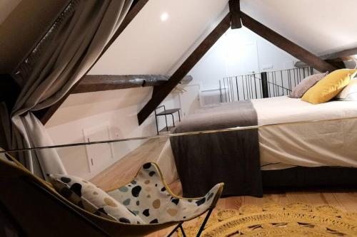 um quarto com duas camas e uma cadeira em Ficus Áurea em Aveiro