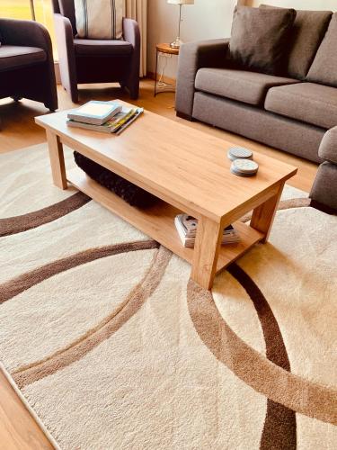 a living room with a wooden coffee table on a rug at Residentie Mariposa in Knokke-Heist