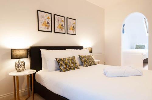 ein Schlafzimmer mit einem großen weißen Bett und Kissen in der Unterkunft Atlas House - Ideal for Contractors or Derby County Fans in Derby