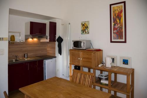 uma pequena cozinha com uma mesa e um micro-ondas em Gîte Les chênes em Fontenilles