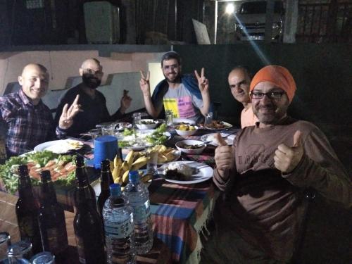 a group of men sitting around a table with food at Viyanga Homestay in Ella