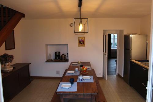 a kitchen with a wooden table and a refrigerator at Chez Maria in Cherrueix