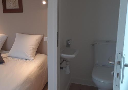 ein weißes Bad mit einem WC und einem Waschbecken in der Unterkunft Chez Maria in Cherrueix