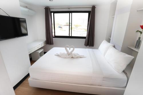 a white bedroom with a white bed and a window at C Tower Hotel in Surat Thani