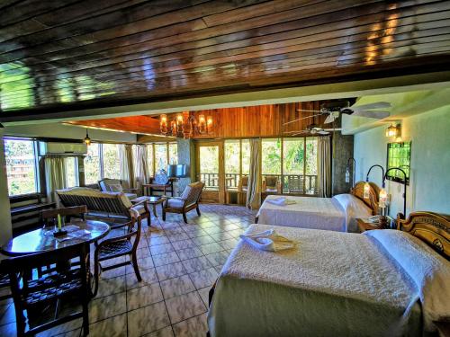 una camera d'albergo con due letti e un tavolo con sedie di Hotel Costa Verde a Manuel Antonio