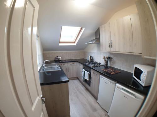 una pequeña cocina con fregadero y microondas en 4 Bedroom House en Weymouth