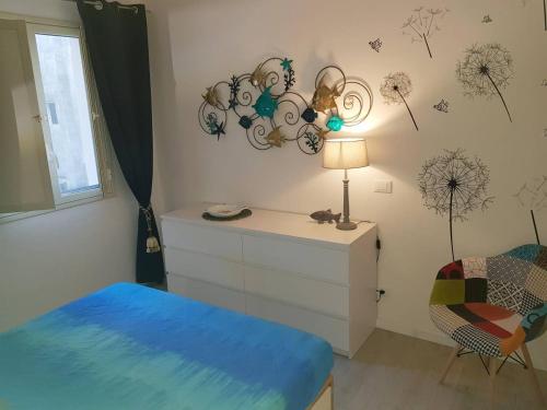 - une chambre avec un lit, une commode et une chaise dans l'établissement Lo Duca Apartments, à Cefalù