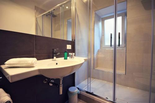 La salle de bains est pourvue d'un lavabo et d'une douche. dans l'établissement Lo Duca Apartments, à Cefalù