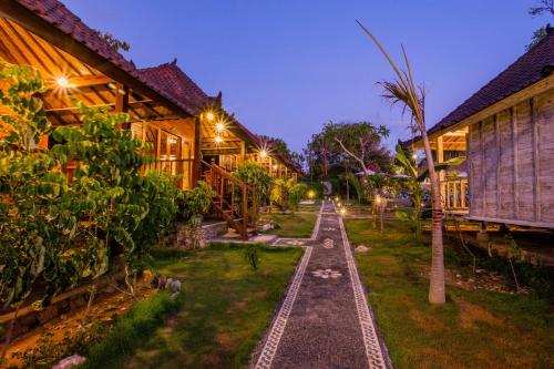 a house with a garden in the night at D'Coin Lembongan in Nusa Lembongan
