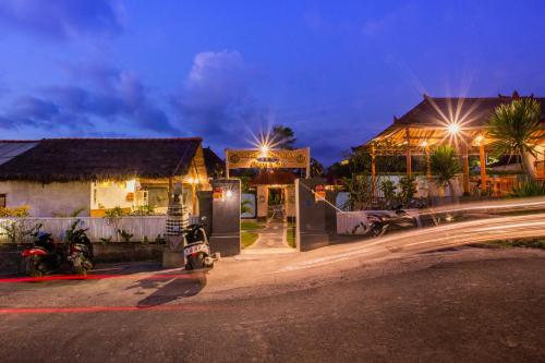 a city street at night with buildings and motorcycles at D'Coin Lembongan in Nusa Lembongan