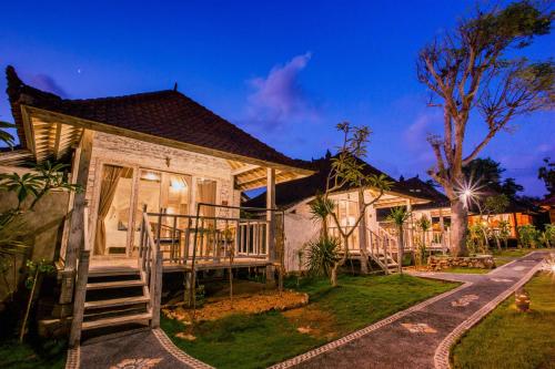 a house with a porch and a deck at D'Coin Lembongan in Nusa Lembongan