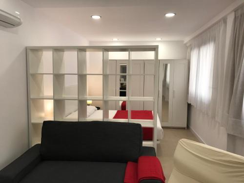 a living room with a black couch and a bed at Bet Apartments - Reig in Valencia