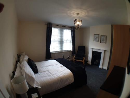 a bedroom with a bed and a fireplace and a window at 4 Bedroom House in Weymouth