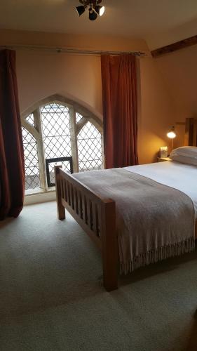 Un dormitorio con una cama grande y una ventana en The Belfry at Yarcombe en Yarcombe