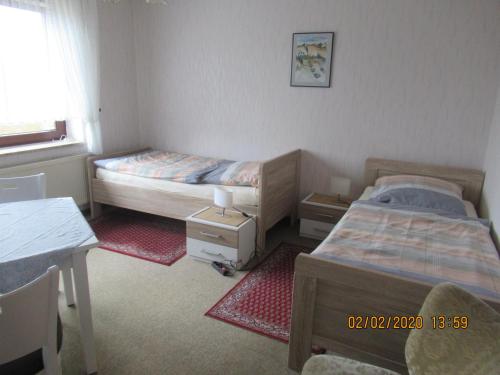 1 dormitorio con 2 camas, escritorio y mesa en Ferienwohnung "Romaker" en Jeersdorf