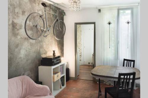 une chambre avec une table et un vélo suspendu au mur dans l'établissement Tour de France historique et châteaux de Loire, à Orléans
