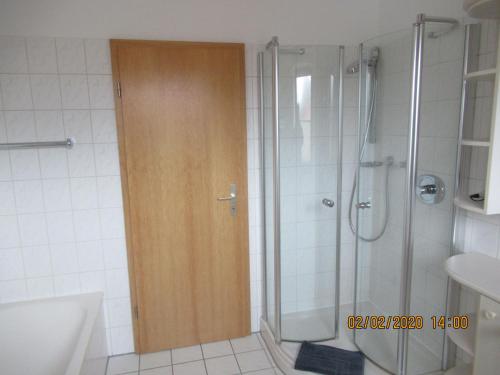 baño con ducha y puerta de madera en Ferienwohnung "Romaker", en Jeersdorf