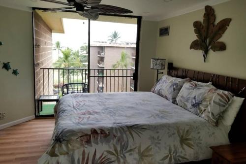 a bedroom with a bed and a large window at Oceanfront penthouse with amazing views at Kauhale Makai in Kihei