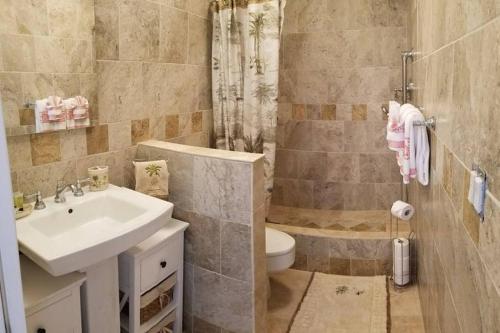 y baño con lavabo, aseo y ducha. en Oceanfront penthouse with amazing views at Kauhale Makai en Kihei