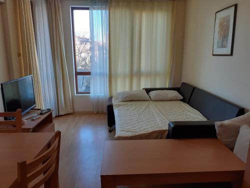 a living room with a bed and a television at Panorama Vigo Nesebar in Nesebar